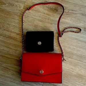 Black Tory Burch wallet and red Tory Burch crossbody bag together